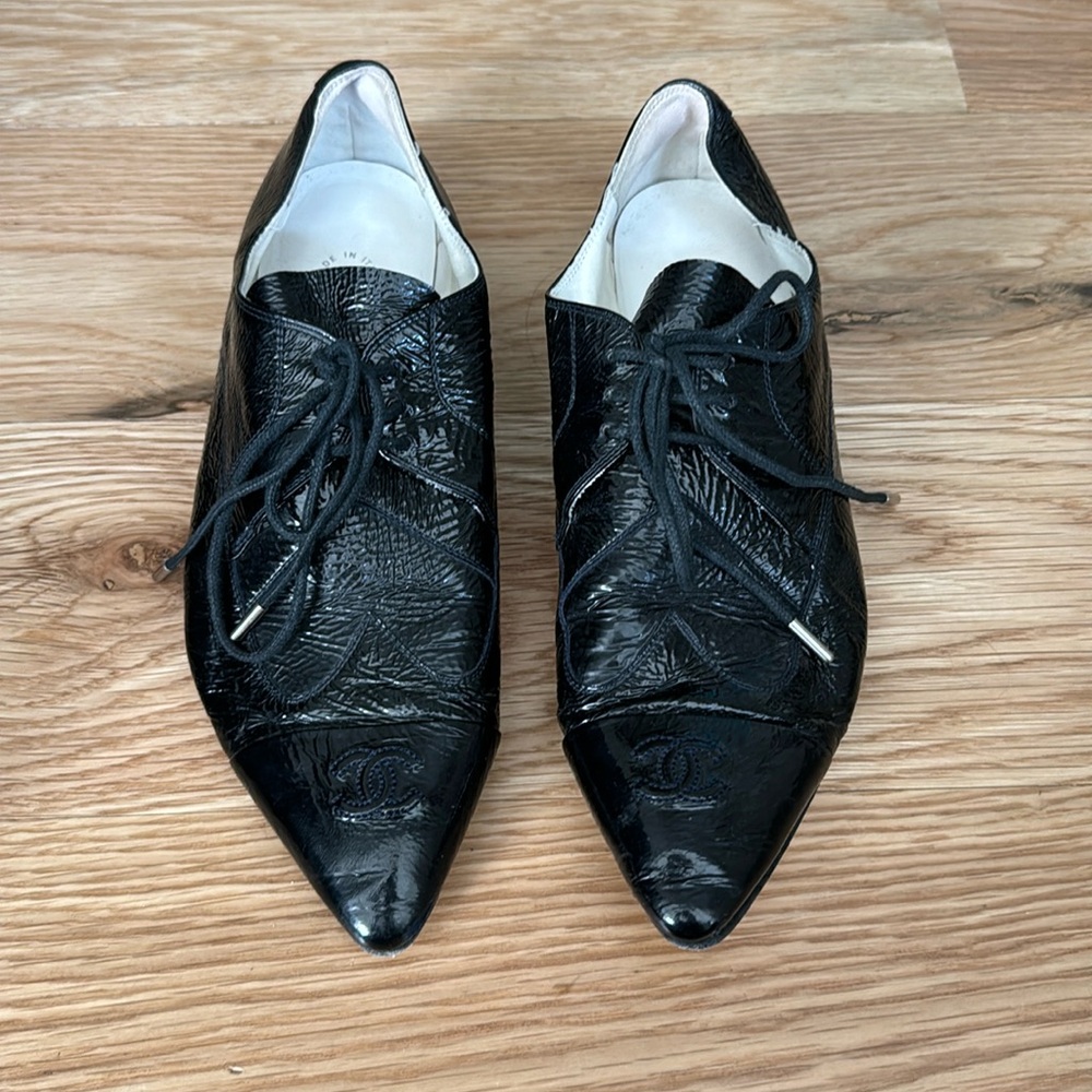 Lace up Chanel patent leather shoes with heart detail and CC logo.